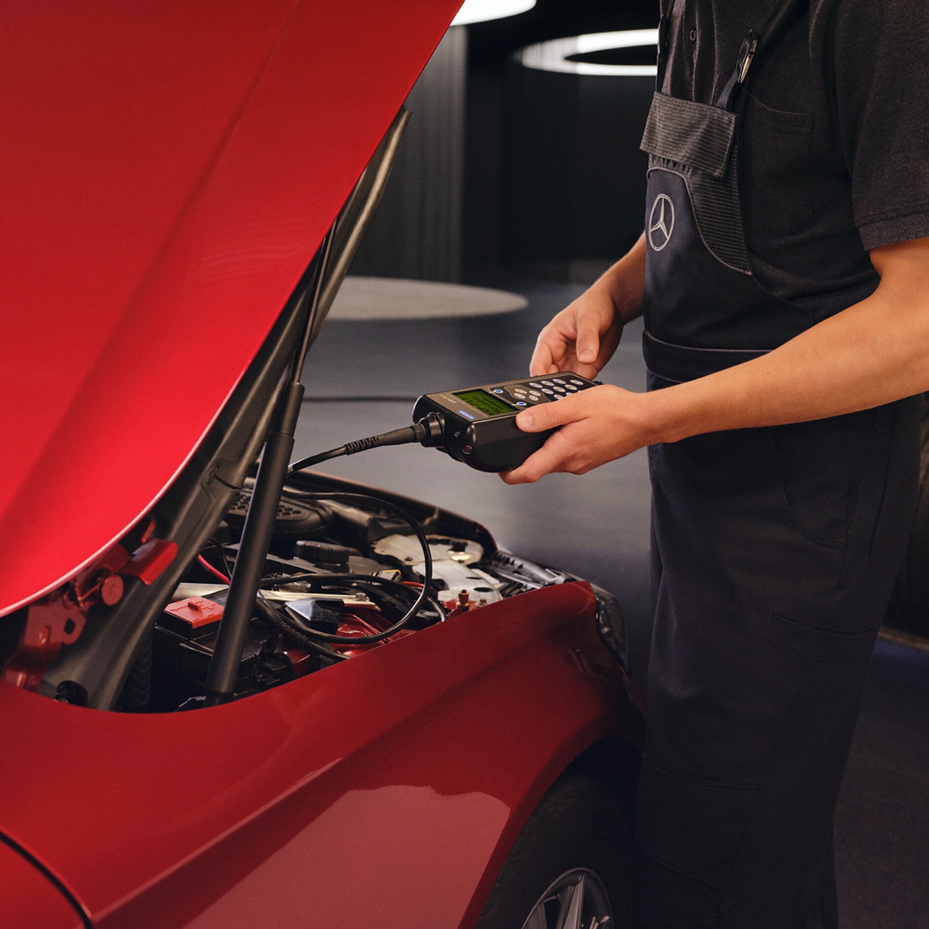 Serviceaftale | Kundeservice | Mercedes-Benz Mercedes-Benz tekniker udfører serviceeftersyn af rød Mercedes-Benz