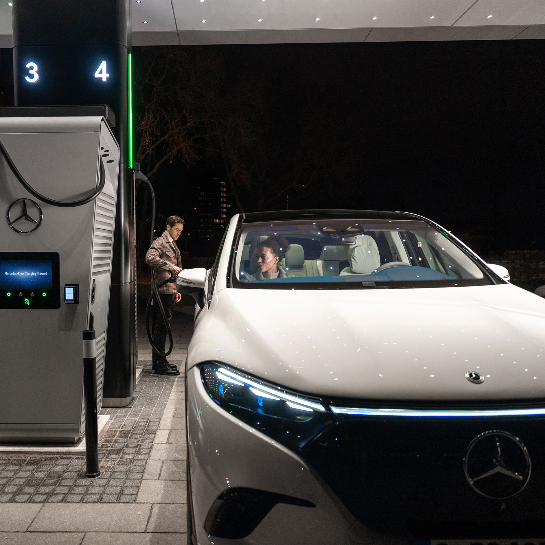 Ladeløsninger | Teknologi | Mercedes-Benz Mercedes-Benz CLA holder på en gade og er tilsluttet en ladestation.